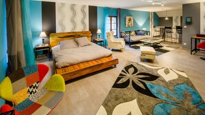 Una habitación de hotel moderna con una cama grande, un escritorio y una zona de comedor.