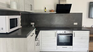 A compact kitchen with a microwave, oven, and a small countertop area.