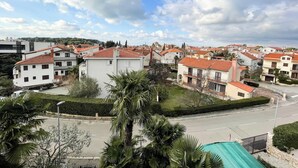 A residential area with houses featuring red-tiled roofs and white walls, surrounded by greenery and a clear sky. - App Villa Palma 2 (Rovinj)