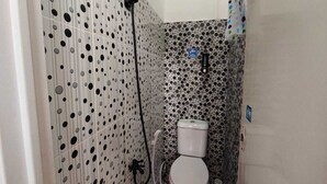 Pieni, käytännöllinen kylpyhuone, jossa on wc, suihku ja pesuallas.