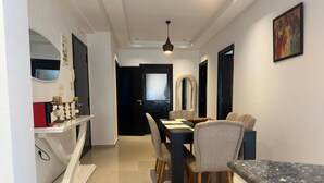 A modern dining area with a black table, grey chairs, and a black countertop. - Chic & Elegant Stay in Central Rabat (Rabat)