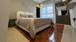 A bedroom with a bed, a dresser, a mirror, and a window with curtains. - Chic & Elegant Stay in Central Rabat (Rabat)