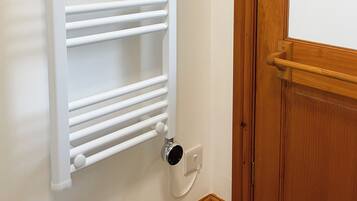 Un termosifone bianco montato su una parete, con un telaio di legno a destra.