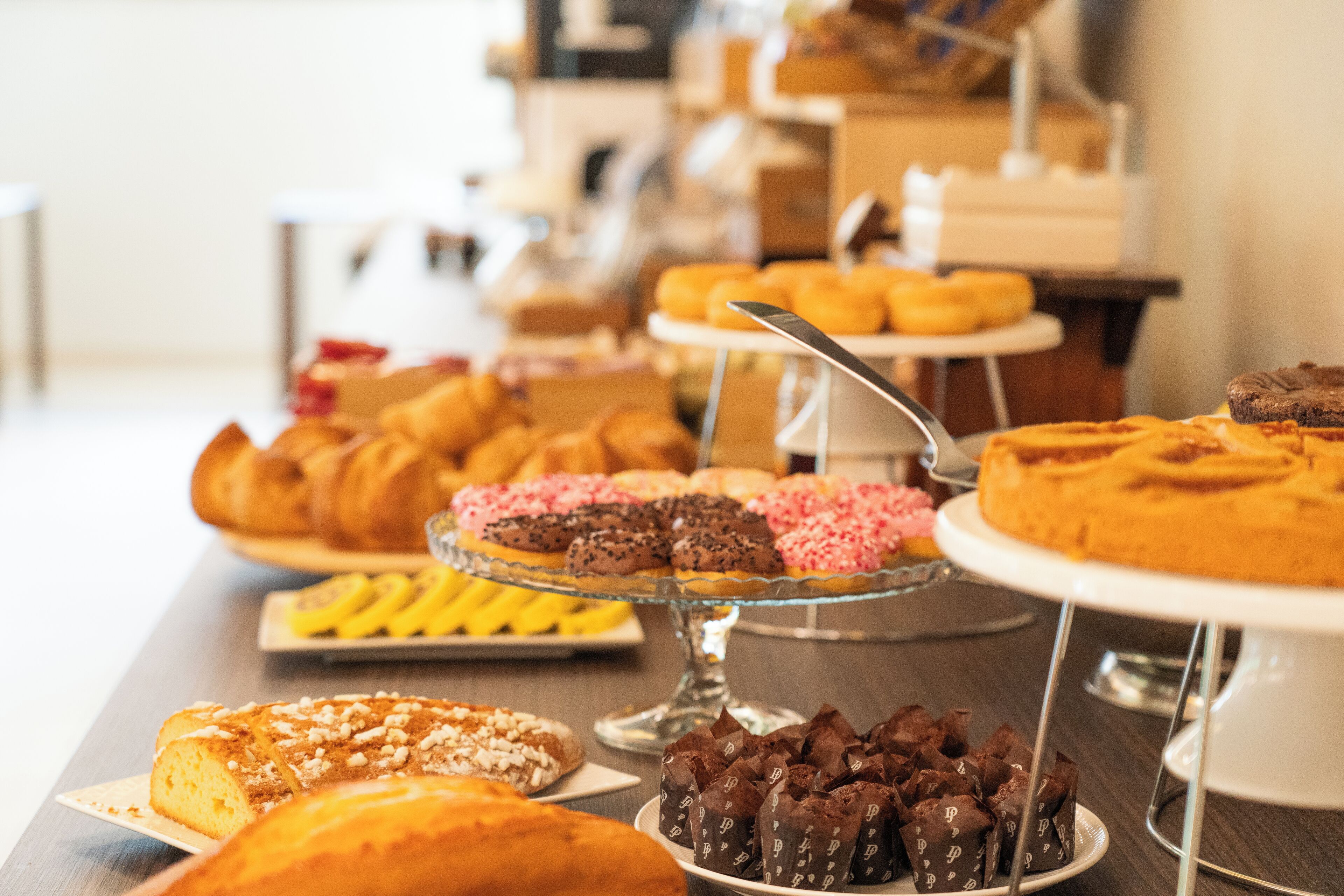 A buffet with various pastries and desserts on display.