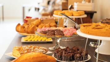 A buffet with various pastries and desserts on display.