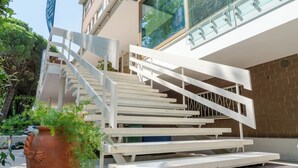 Een modern gebouw met een witte trap die naar een balkon leidt.
