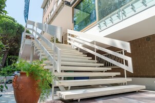 Un edificio moderno con una scala bianca che conduce a un balcone.