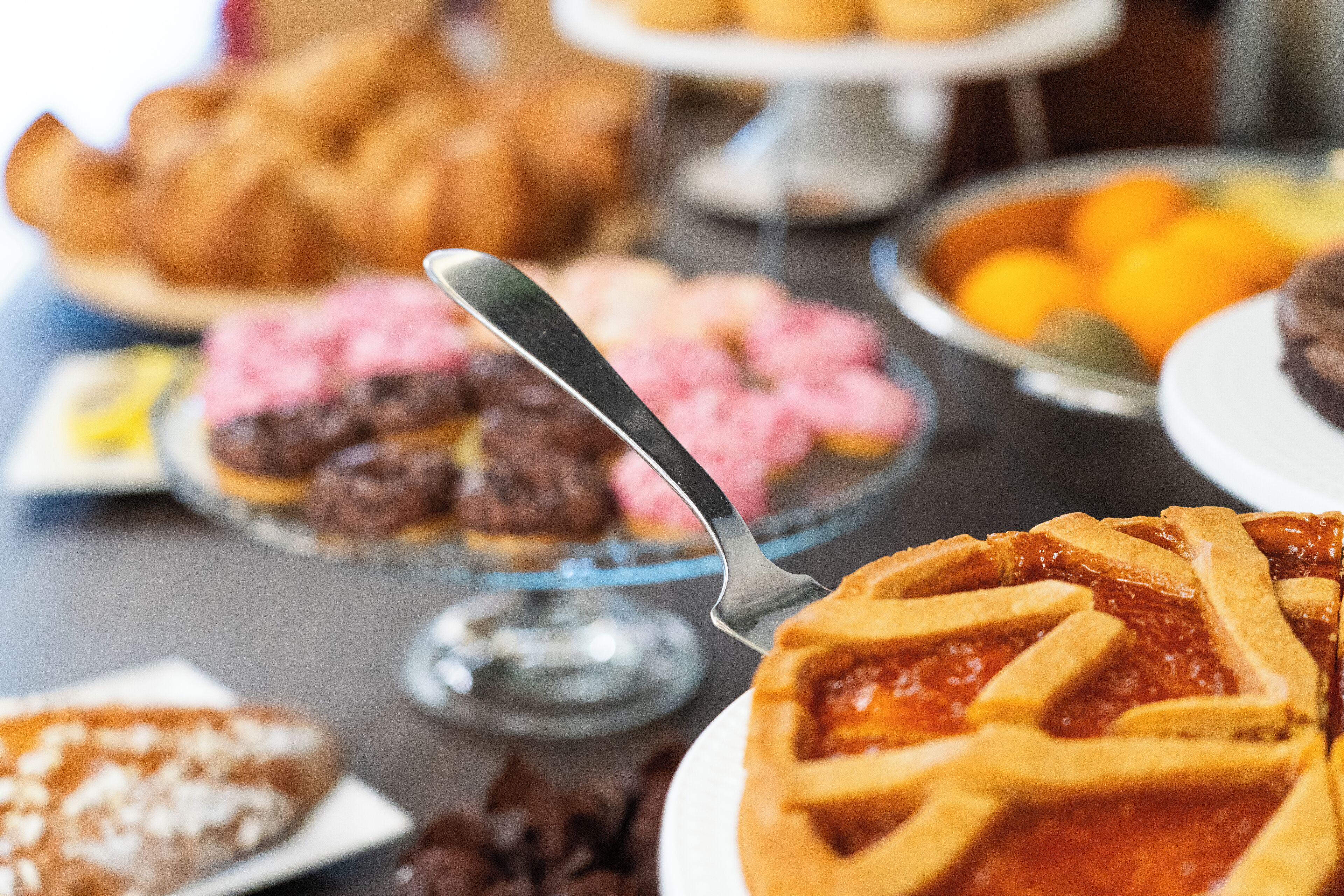 Varietat de postres sobre una taula buffet, com ara pastissos, forns i fruita.