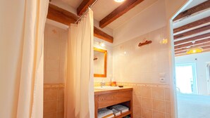 Une salle de bain avec un meuble-lavabo en bois, un miroir et un porte-serviettes.