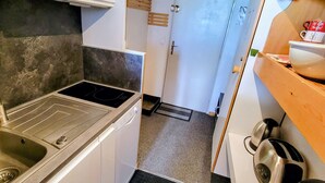 A compact kitchen with a built-in stove, a sink, and a small countertop.