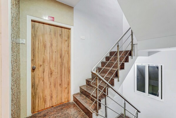 A staircase with metal railings leading to a wooden door.