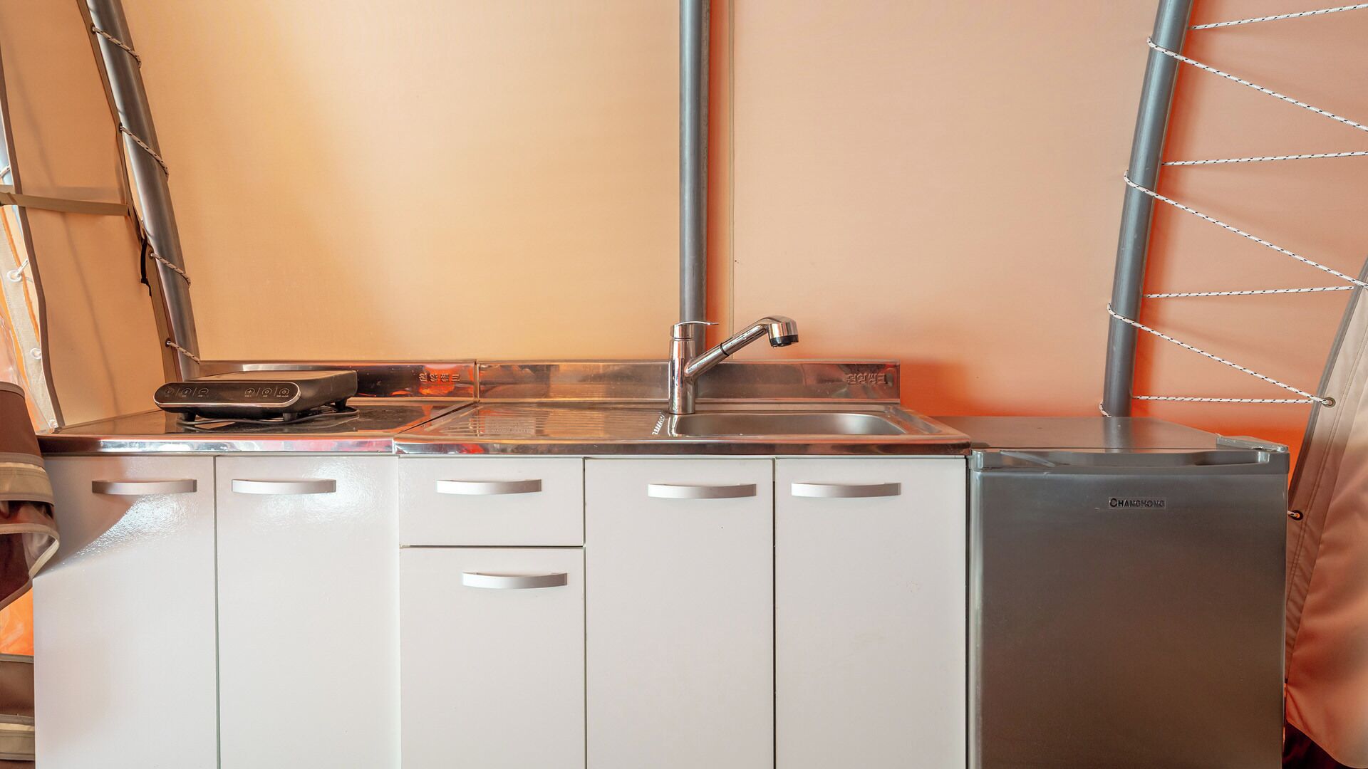 A compact kitchen with a sink, stove, and cabinets.