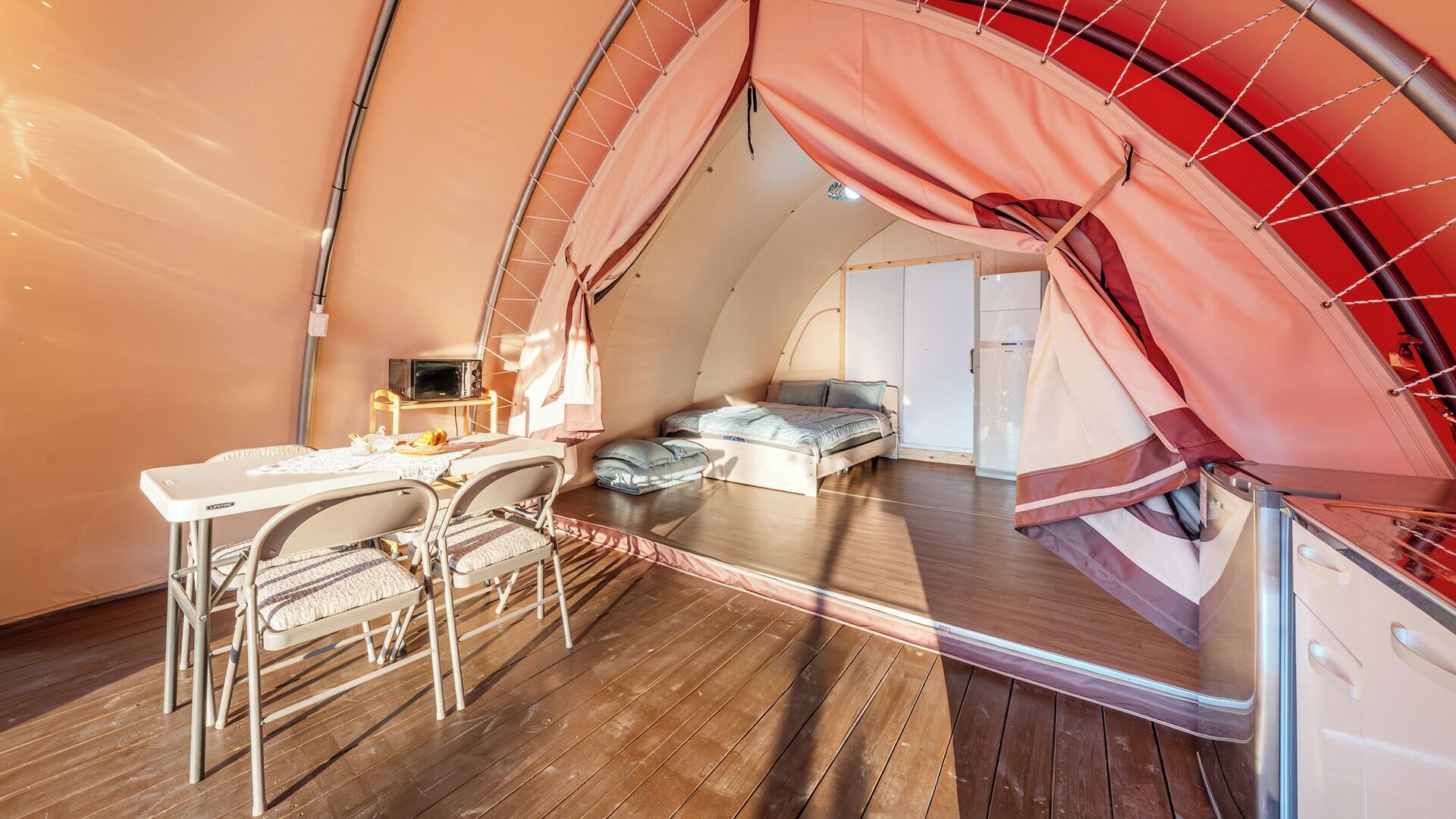A cozy, compact room with a bed, a small table, and a chair.