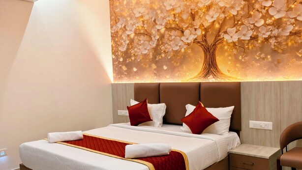 Quarto de hotel moderno com uma cama grande, mesa de cabeceira, cadeira e ar condicionado fixado na parede.