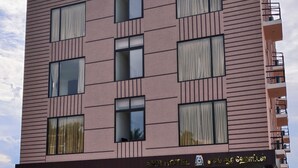 Um hotel de vários andares com design moderno, caracterizado por grandes janelas e fachada plana.