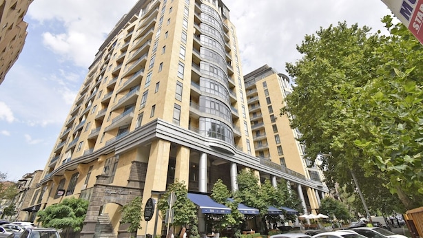 A high-rise hotel with multiple balconies and a curved corner design.