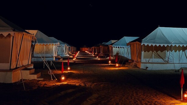 A series of tents arranged in a row with a central pathway. - Talai Desert Camp (Jaisalmer)