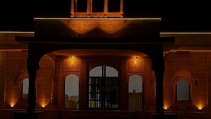 A building with a traditional architectural style, featuring arched doorways and a balcony with ornate railings. - Talai Desert Camp (Jaisalmer)