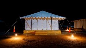 A tent with a flat roof and a platform in the middle, surrounded by sand. - Talai Desert Camp (Jaisalmer)