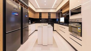 A modern kitchen with built-in appliances, a central island, and a sleek design. - Kennah 3BR with Balcony | Stone Residence, New Cairo - Families Only (New Cairo)