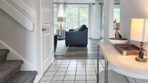 A hallway leading to a living area with a sofa and a lamp. - Heron Marsh Villa 78 (Pawleys Island)