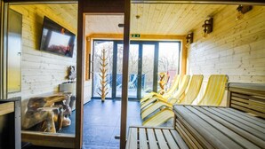 A wooden interior with a bench, a television, and a tree sculpture. - Pensjonat Fitness i Spa Gregor (Zielona Góra)