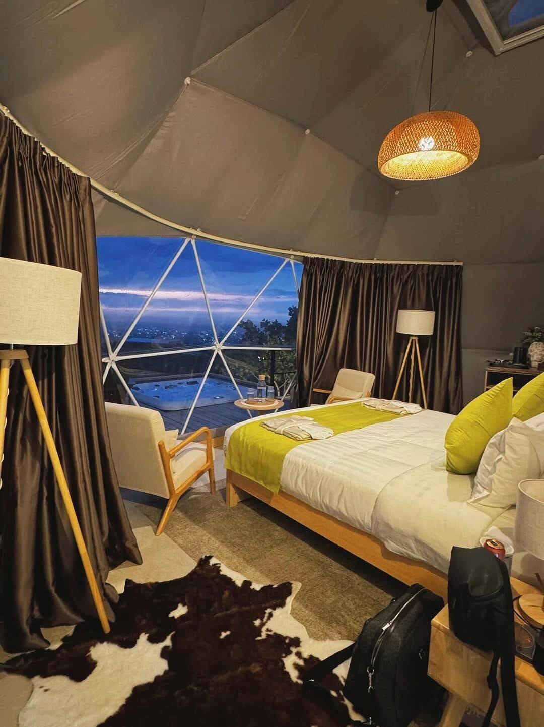 Una habitación con tienda de campaña, una cama, una silla, una lámpara y vistas a un paisaje.