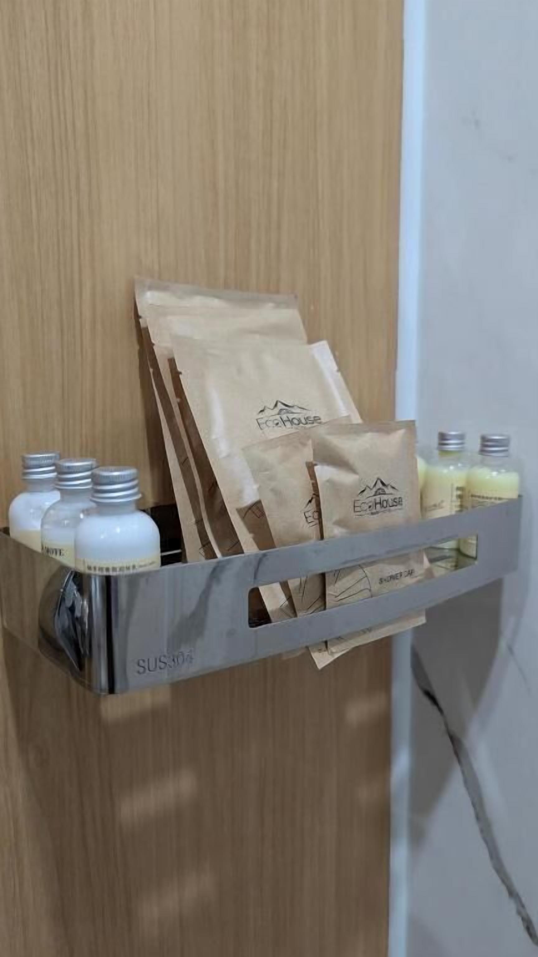 Estante metálico con una puerta de madera al fondo, que contiene varias bolsas de papel marrón y botellas.