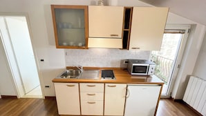 A compact kitchen with a built-in microwave, a sink, and a small refrigerator.