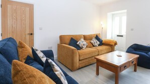 A living room with a sofa, a coffee table, and a door.