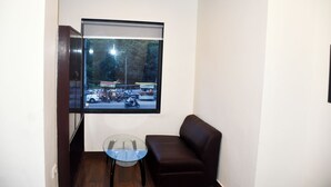 Una habitación con un ventanal grande, una mesa de vidrio y un sofá marrón.