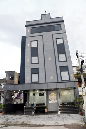 Et moderne hotel med en flad facade, store vinduer og et skilt der viser, at det er Hotel Sridevi.