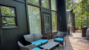 Eine Terrasse mit Korbmöbeln und einem Grill.