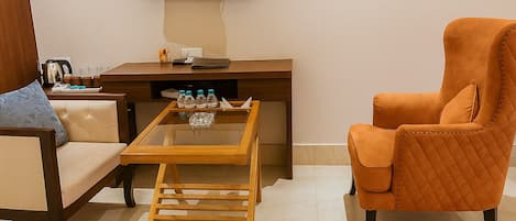 Una sala de estar moderna con un sofá, un sillón, una mesa de centro y un escritorio con televisor de pantalla plana.