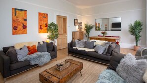 A modern living room with two sofas, a coffee table, and a dining area with a wooden table and chairs.