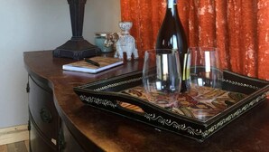 A bottle of wine on a tray, a lamp, and a small figurine on a wooden table. - Romantic Yucca Valley Cabin with Hot Tub (Yucca Valley)