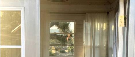 Una cabaña con una cama, una ventana con vistas y un cartel sobre la puerta.