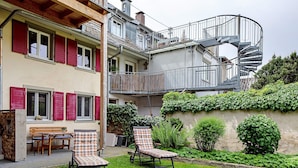A two-story building with a spiral staircase, outdoor seating, and a garden. - Apartment 'Belchenwind Type A, 45sqm' (Münstertal)