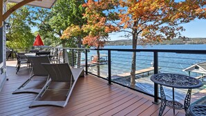 A wooden deck with outdoor furniture, a table, and chairs.