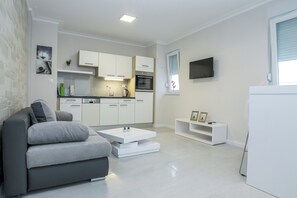 Departamento Deluxe, 2 habitaciones, balcón | Área de sala de estar | Televisión de 50 pulgadas con canales digitales 