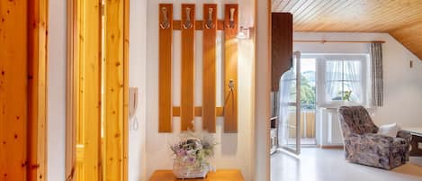 Een houten interieur met een houten kast, een stoel en een wandlamp.