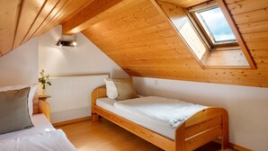 A small, wooden-paneled room with a single bed, a skylight, and a radiator. - Holiday Apartment with Mountain View 1 with Balcony and Wi-Fi (Wieden)