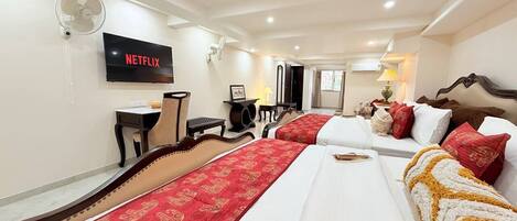 Una habitación de hotel con cama, televisión, escritorio y silla.