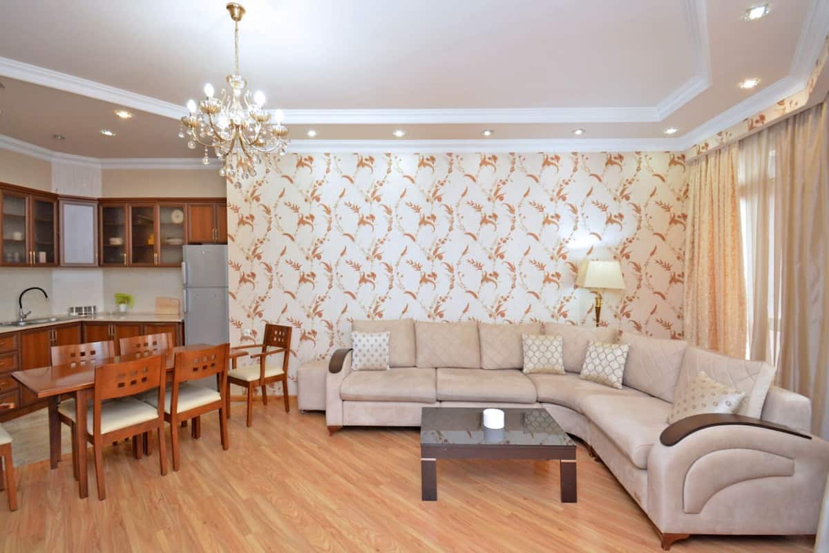 Ein Wohnzimmer mit einer Couch, einem Couchtisch und einem Essbereich mit Stühlen und einem Tisch.