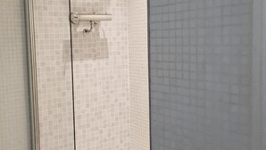 A glass-enclosed shower stall with a tiled wall and a white floor. - Cityscape Apartment in Rotunda Bham (Birmingham)
