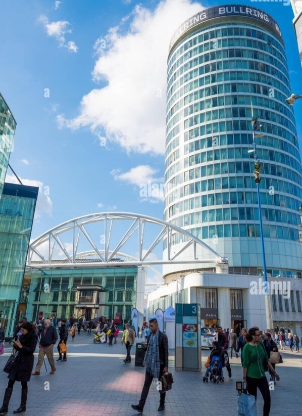Un edificio moderno con fachada de vidrio curva y un letrero que dice "BULLRING".