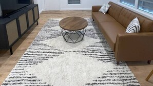 Een moderne woonkamer met een bank, salontafel en tv-meubel.
