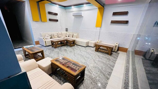 Uma sala de estar moderna com um sofá seccional, duas mesas de centro de madeira e um chão de mármore.