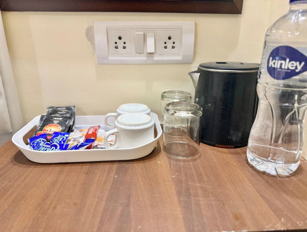 A kitchen counter with a tray of snacks, a kettle, a water bottle, and a coffee maker.