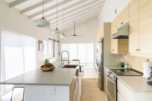 A modern kitchen with a large island, built-in appliances, and pendant lighting. - Modern Thoughtfully Updated Miami Pool Home - Casa Carmela (Miami)